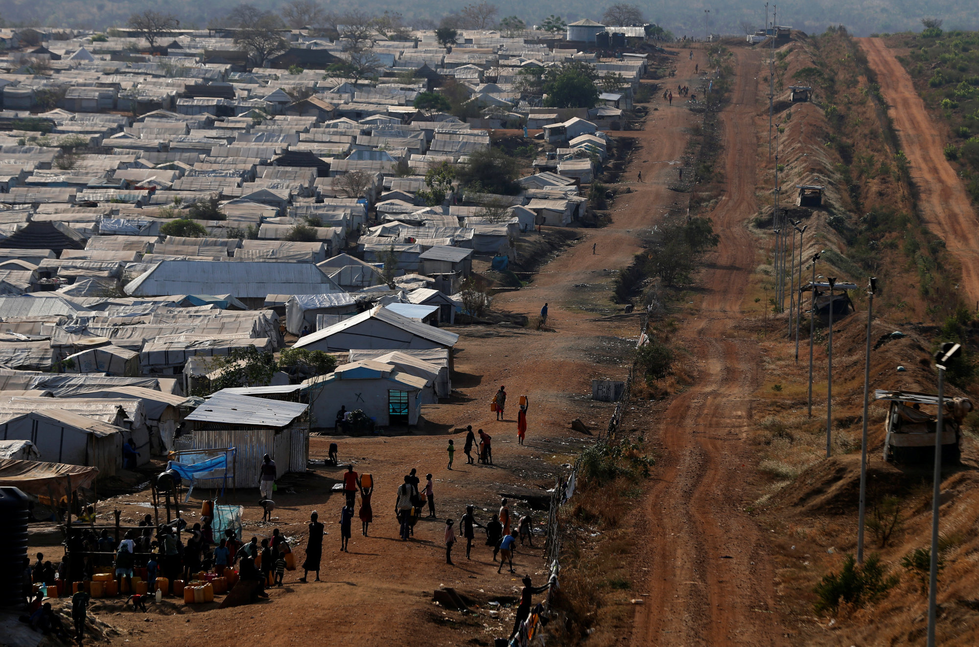 Internally displaced people gather by a water collection point in a United Nations Mission in South Sudan PoC site, outside the capital Juba